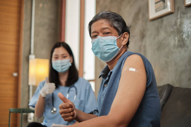 istock Elderly patient with face mask thumb up when vaccinated. 1339379426