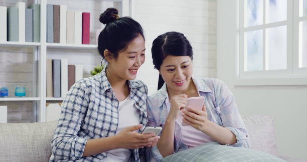 istock women friends at home using smart phones 1339385160