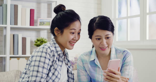 istock girls smiling joyfully looking at the cellphone 1339385726