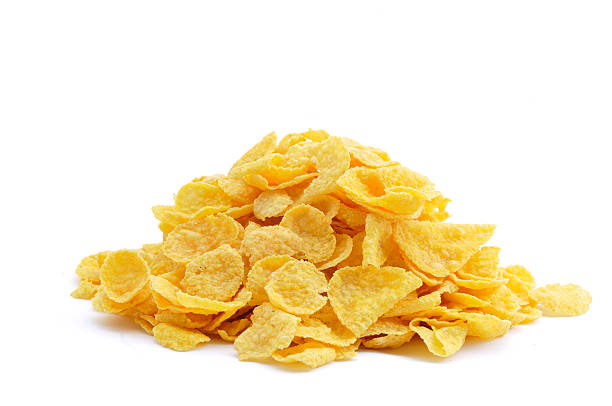 Pile of Cornflakes A small pile of cornflakes isolated on a white background. cornflakes stock pictures, royalty-free photos & images