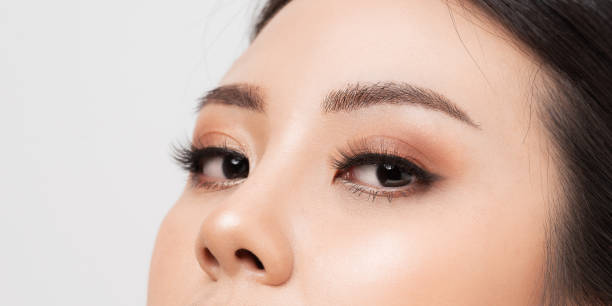 primo piano macro occhio donna. closeup viso donna asiatica pelle perfetta. - ciglia finte foto e immagini stock