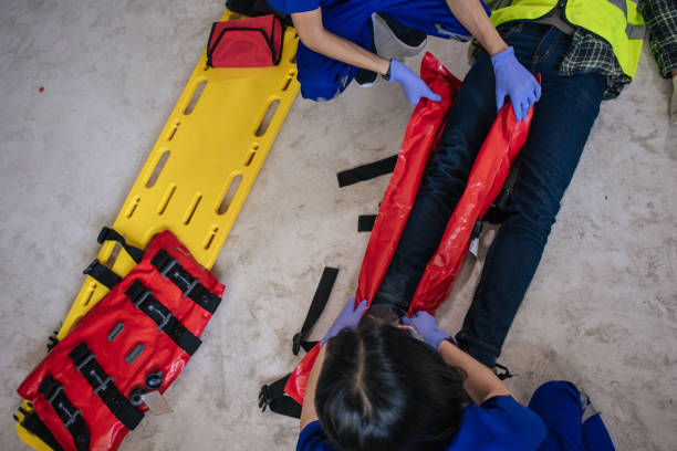 equipe paramédica socorrista incidente perna quebrada com tala de vácuo da perna e maca para se mover. - tala - fotografias e filmes do acervo