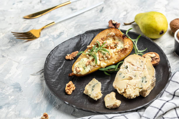 istock Blue cheese with pears and walnuts. Appetizer with pear baked with dorblu, gorgonzola, roquefort. Delicious balanced food concept 1339402489