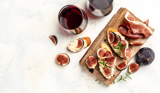 Appetizers. antipasti, snacks and wine. Sandwich with prosciutto, cream cheese and figs. banner, menu, recipe place for text, top view stock photo