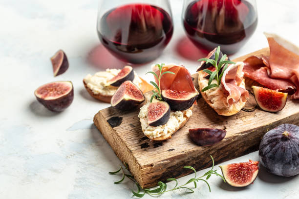 Appetizers. antipasti, snacks and wine. sandwiches with jamon, cottage cheese and figs. Traditional Bruschetta set with Parma dried ham and prosciutto stock photo