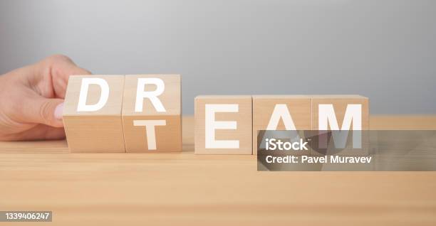 Dream Team Businessman Turns Cubes And Changes The Word Dream To Team Wooden Table Grey Background Business And Dream Team Concept Copy Space Stock Photo - Download Image Now