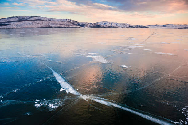 istock Ice on the frozen lake at sunset. 1339406332