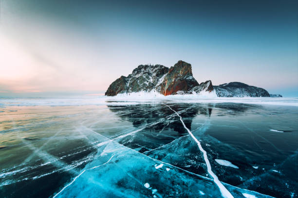 Baikal lake in winter with transparent blue ice. Baikal lake in winter with transparent cracked blue ice. Khoboy cape of Olkhon island, Baikal, Siberia, Russia. Beautiful winter landscape at sunrise. ice floe photos stock pictures, royalty-free photos & images
