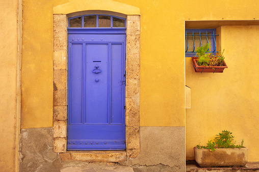Lavender door and yellow facade of the house. Old architecture in Valensole, Provence, France.