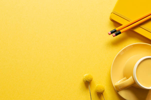 Notebook, pencil, coffee cup on yellow background. flat lay, top view, copy space. workspace stock photo