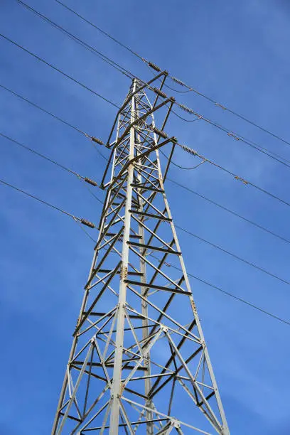 Electric tower view from below under blue sky