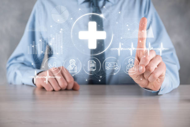 istock Businessman hold virtual plus medical network connection icons. Covid-19 pandemic develop people awareness and spread attention on their healthcare.Doctor,document,medicine,ambulance,patient icon. 1339418616