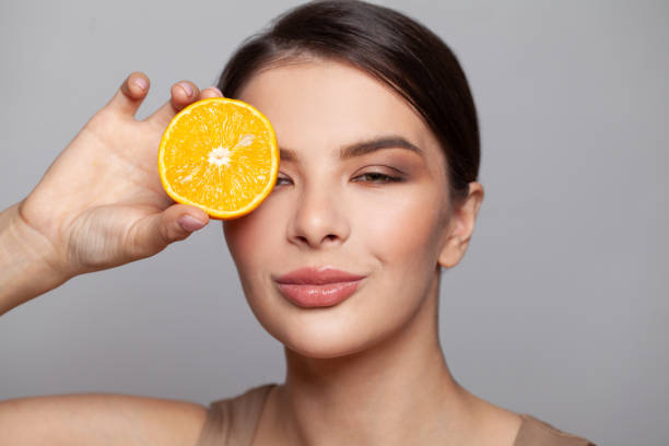 istock Smiling woman with lemon cut in half fruit in hand 1339419572