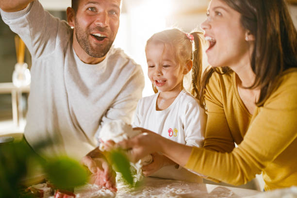istock Happy parents and their daughter making a cake in the kitchen. 1339419846