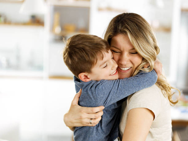 istock Happy boy embracing with his single mother at home. 1339419955