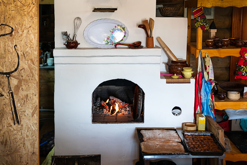 Rustic stove in the countryside with pies, in the interior of a wooden house. The concept of village life.