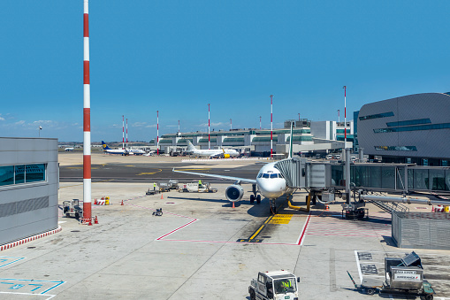 Rome, Italy - August 8, 2021: view to terminal and gate with aircraft at roman airport Fiumicino in Rome. It is the largest airport in Italy.