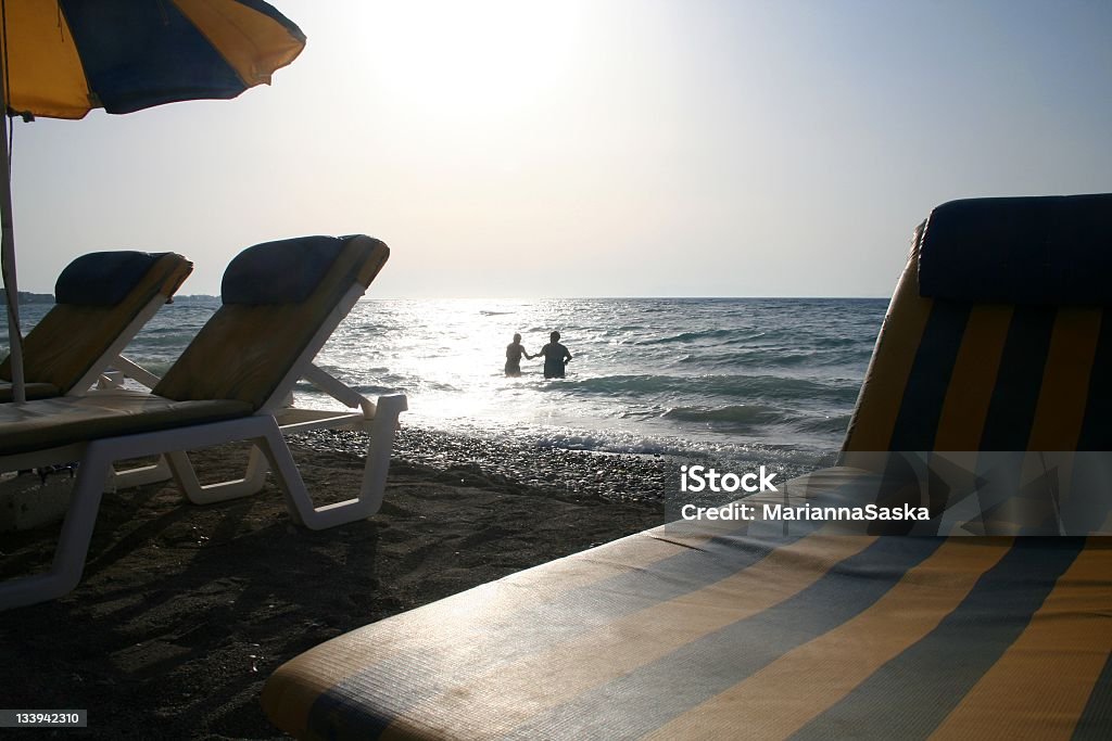 Sunset bathing Two people bathing in the sea at sunset, Rhodes, Greece. Adult Stock Photo