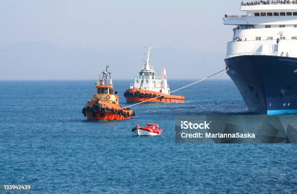 Tugboats Towing A Ferry Into A Harbor Stock Photo - Download Image Now - Tugboat, Small, Large