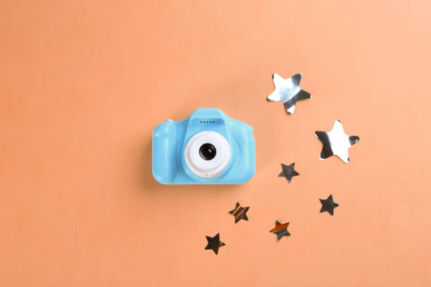 istock Toy camera and stars on orange background, flat lay 1339425308