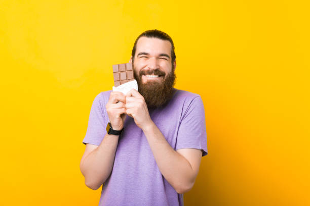 istock Cute bearded chocolate lover is hugging a bar of it. 1339425478