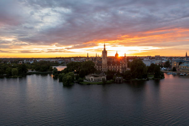sunset on the lake The reflection of the water and the city of Schwerin illuminated by a beautiful sunset schwerin castle stock pictures, royalty-free photos & images
