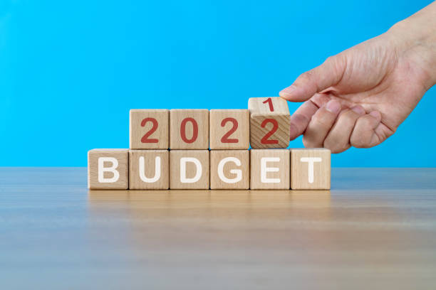 istock Hand turning  blocks from 2021 to 2022 with budget text 1339430174
