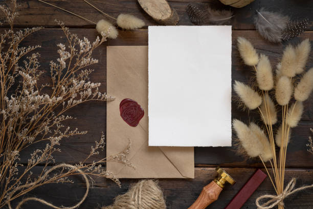 istock Blank paper card on envelope and wooden table with dried plants 1339431648