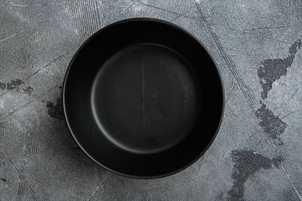 istock Black bowl, with copy space for text or food, with copy space for text or food, top view flat lay , on gray stone table background 1339432147