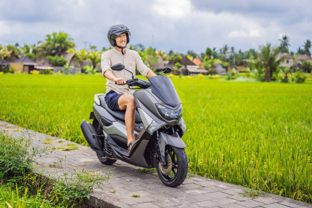 male traveler on a bike among a rice field. tourist travels to bali - bali male beautiful ethnicity imagens e fotografias de stock