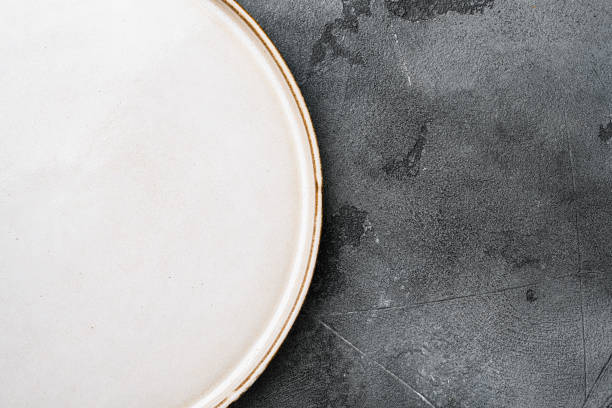 istock Empty white plate porcelain with copy space for text or food with copy space for text or food, top view flat lay , on gray stone table background 1339433965