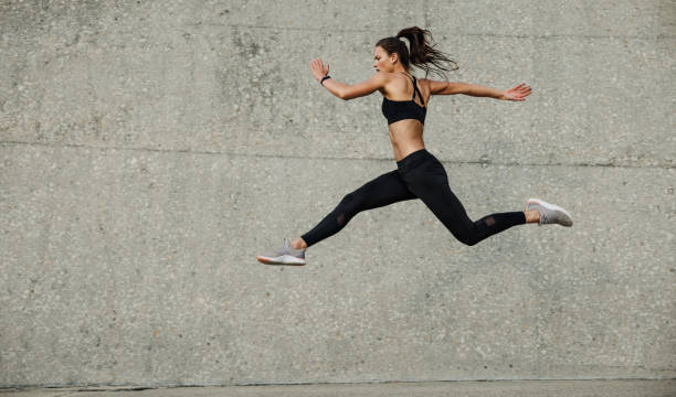 atleta femminile che corre e salta all'aperto - strutting foto e immagini stock