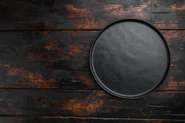 istock Empty black plate, on old dark  wooden table background 1339436761