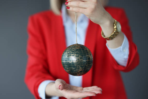 Woman in a business suit holds ball with world map Woman in a business suit holds ball with world map. World politics and diplomacy concept better world stock pictures, royalty-free photos & images