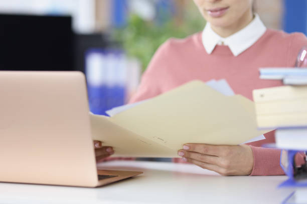 istock Businesswoman examines financial documents at workplace closeup 1339436871