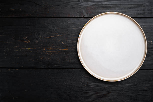 istock Empty dinner plate with copy space for text or food with copy space for text or food, top view flat lay , on black wooden table background 1339437633