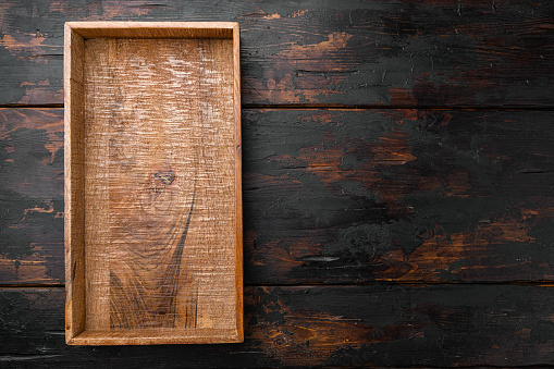 Empty dark wooden box set with copy space for text or food, top view flat lay, on old dark  wooden table background