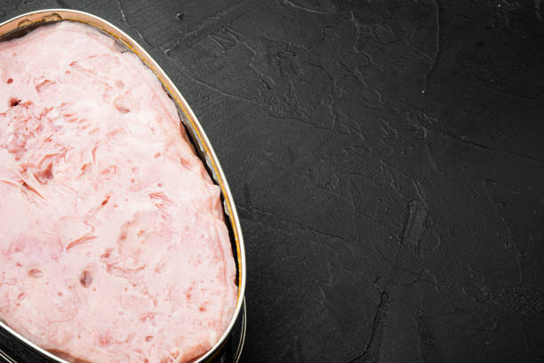 Canned ham set, on black dark stone table background, with copy space for text