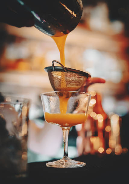 istock bartender pouring a cocktail into a glass 1339440325
