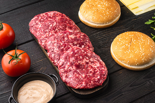 Ground Beef Patties for Grilling and Roasting set, on black wooden table background