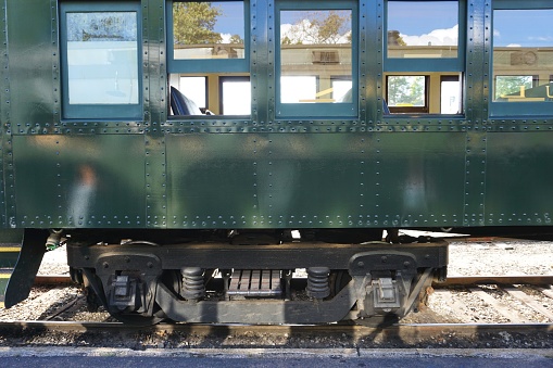 Antique railroad train car sitting in the shade on a railway siding