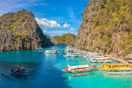 Tour boats by the shore at Coron island, Philippines. Fishermen boats by the sea aerial view