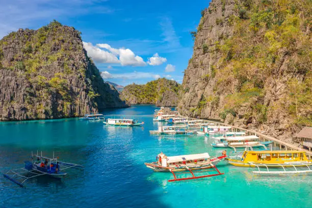 Photo of Tour boats by the shore at Coron island, Philippines. Fishermen boats by the sea aerial view.