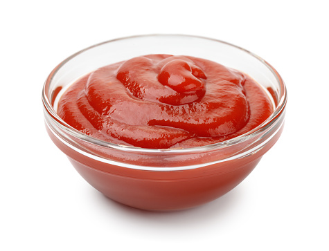 Glass bowl of ketchup isolated on white