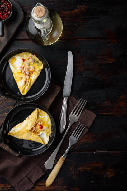 istock Thai  Asian omelette, fresh red chilli, brown and white crabmeat, lemon, Cheddar cheese, eggs, on frying iron pan, on dark wooden background, top view flat lay 1339442826