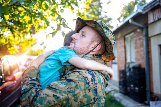 istock Crying little boy and soldier in a military uniform say goodbye before a separation. 1339442925