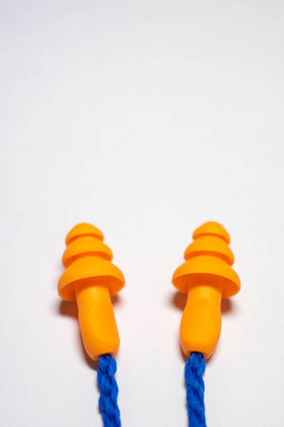 Orange earplugs on blue rope on a white table.