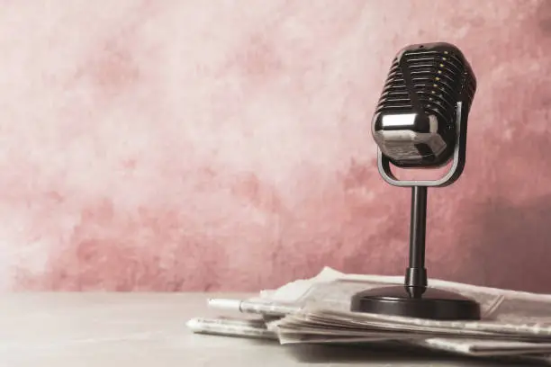 Photo of Newspapers and vintage microphone on table, space for design. Journalist's work