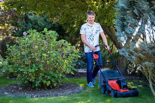 Man using a lawn mower in his back