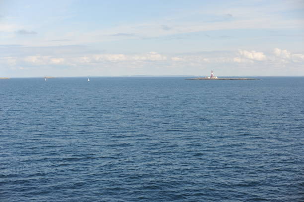 istock Lighthouse on a tiny uninhabited island in Skagerrak Strait between  Sweden and Norway on a sunny day with blue sky, navy blue sea and white clouds 1339448021